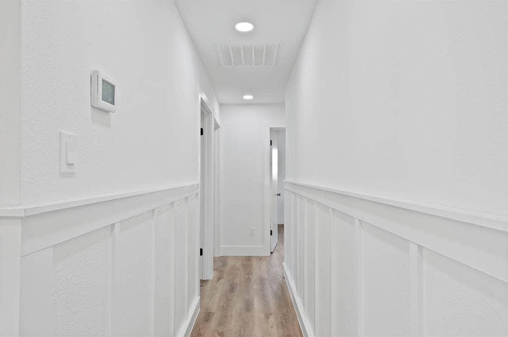 132 Yorkshire Drive, Cedar Hill, TX 75104 Hallway featuring light wood-finish flooring, white board and batten wall treatment, white walls, and recessed lighting