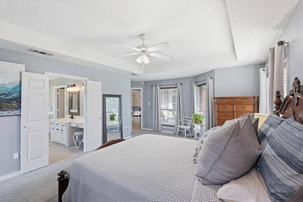 510 Saralvo Road, Midlothian, TX 76065 Recessed ceiling with ceiling fan, tray ceiling, and bay window featuring horizontal blinds and curtains