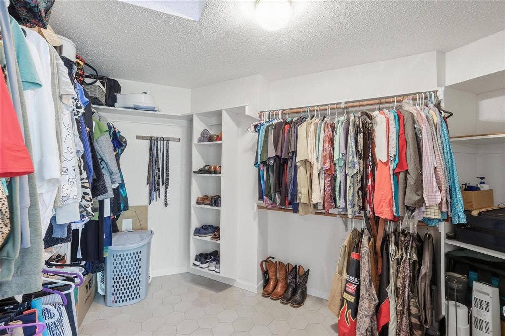510 Saralvo Road, Midlothian, TX 76065 Expansive walk-in closet featuring white walls, overhead lighting, and hexagonal tile flooring