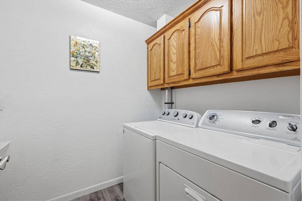 510 Saralvo Road, Midlothian, TX 76065 Laundry area featuring overhead wood cabinetry and wood-finish flooring