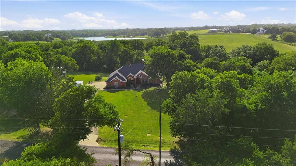 510 Saralvo Road, Midlothian, TX 76065 Aerial perspective showcasing a single-story brick residence with a dark roof