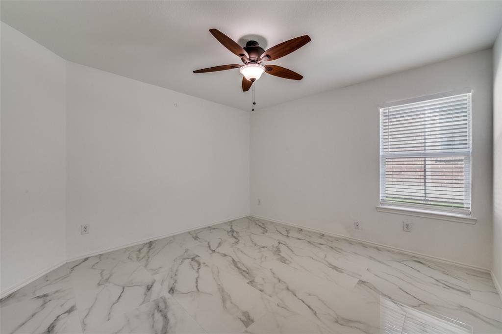 12841 Serenity Drive, Frisco, TX 75035 Room featuring white walls, marble-patterned tile flooring, and a ceiling fan with integrated lighting