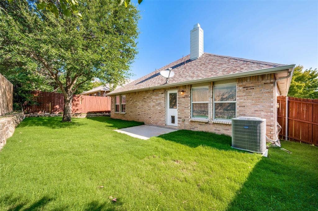 12841 Serenity Drive, Frisco, TX 75035 Expansive backyard featuring a mature tree, manicured lawn, and privacy fencing
