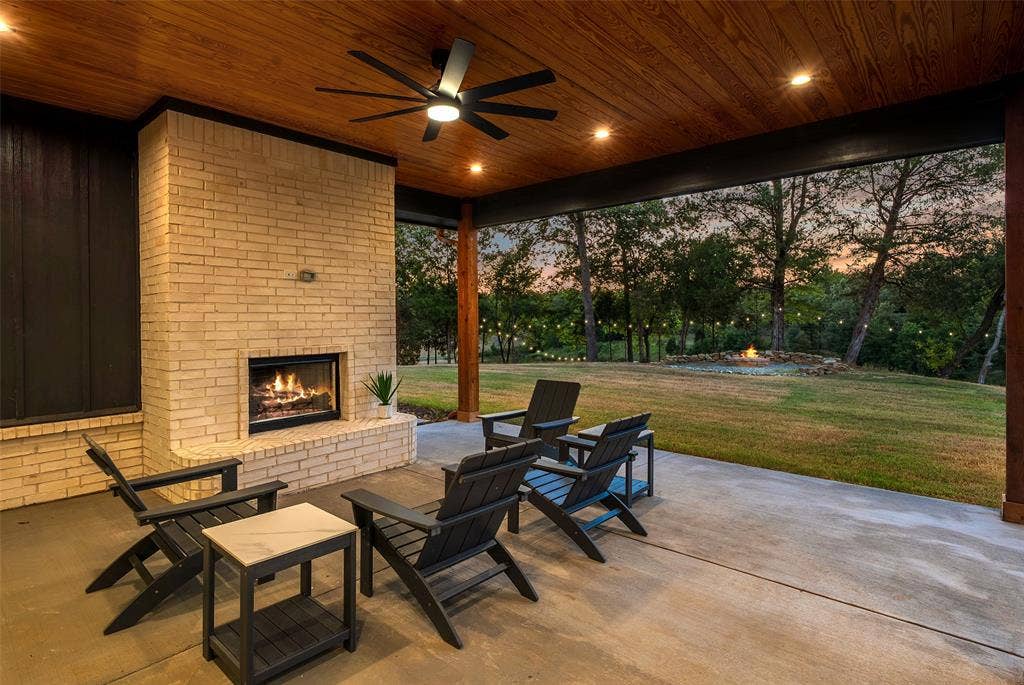 14120 Park Way, Log Cabin, TX 75148 Covered patio with wood burning fire place. Additional covered outdoor area for additional furniture like a dining table and and comfortable seating.