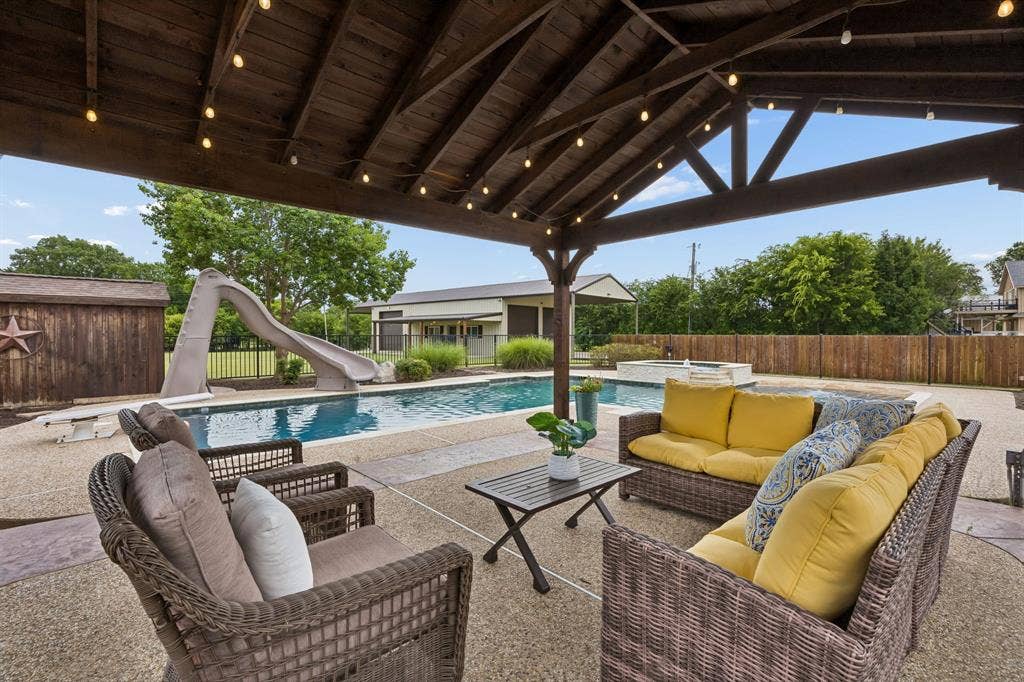 1700 Rock Ridge Road, Lucas, TX 75002 Relax beneath this outdoor living area overlooking the sparking pool. It's such a great pool for all ages with the spa, diving board, and slide!
