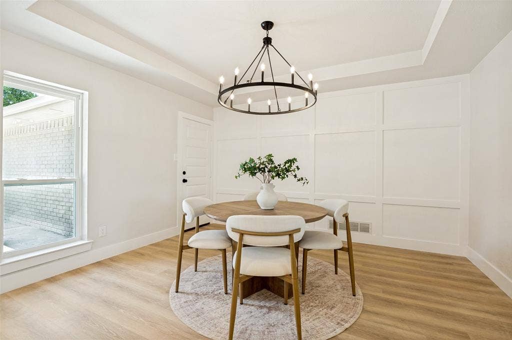109 Shadow Drive, Red Oak, TX 75154 Dining space featuring wood-finish flooring, a tray ceiling, and a black chandelier