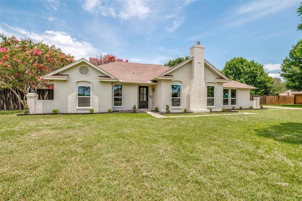 109 Shadow Drive, Red Oak, TX 75154 Single-story brick residence with a prominent chimney, arched window details, a gabled roofline, and established landscaping