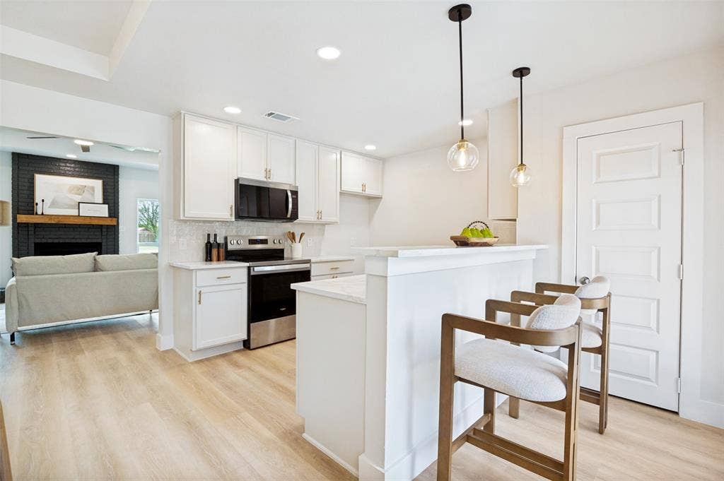 109 Shadow Drive, Red Oak, TX 75154 Modern kitchen featuring white cabinetry, light-toned wood-finish flooring, stainless steel appliances, a white tile backsplash, and recessed lighting