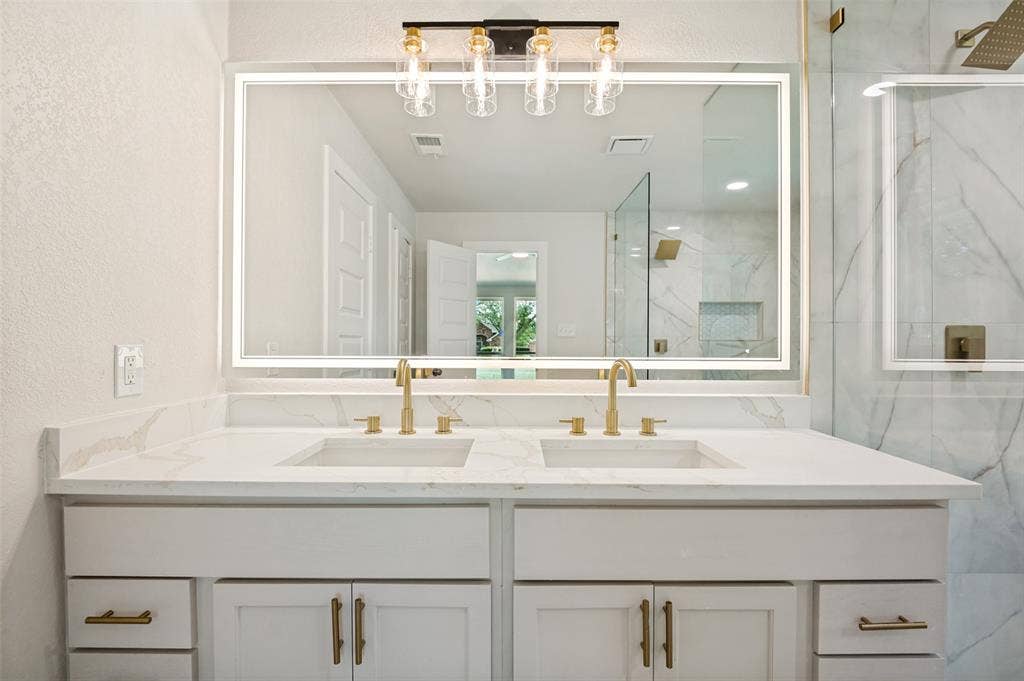 109 Shadow Drive, Red Oak, TX 75154 Double vanity with integrated sinks and white countertops, featuring gold-toned faucets