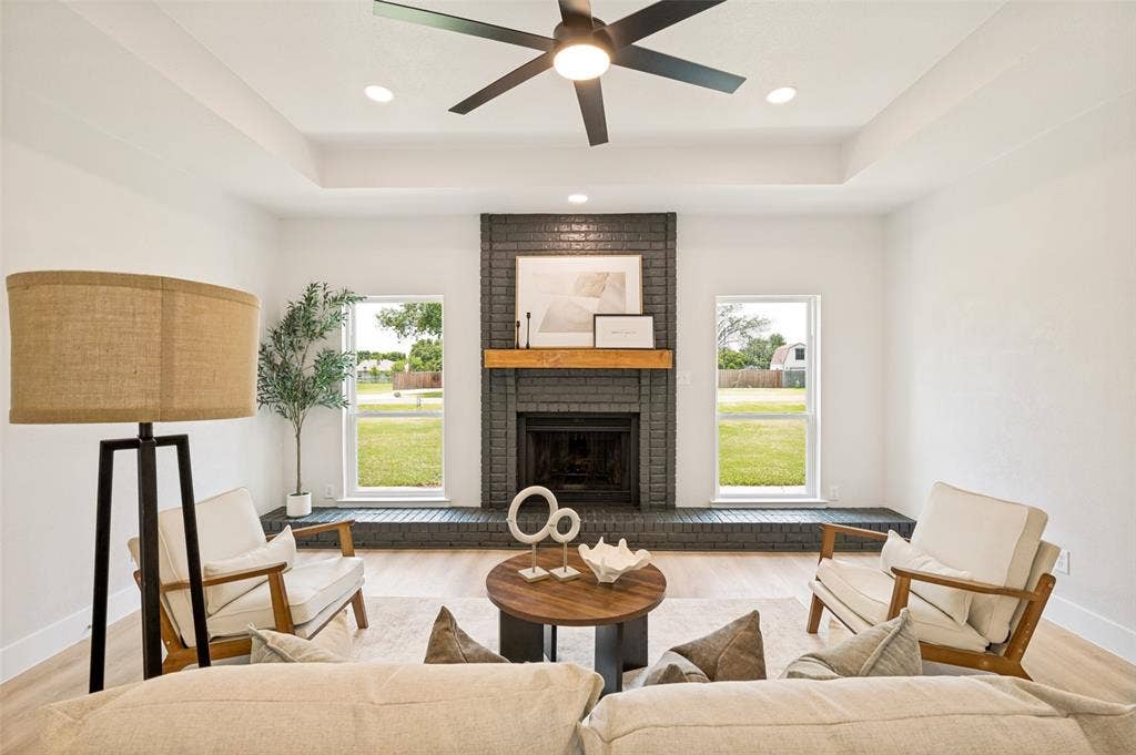 109 Shadow Drive, Red Oak, TX 75154 Living area with a dark brick fireplace, a light wood mantel, and a tray ceiling