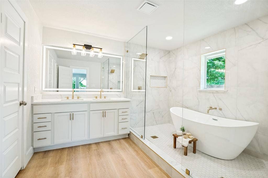 109 Shadow Drive, Red Oak, TX 75154 Full bathroom featuring a frameless glass shower enclosure, a freestanding soaking tub, and a dual vanity with gold-tone fixtures