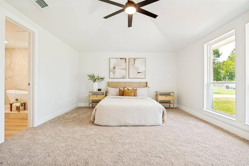 109 Shadow Drive, Red Oak, TX 75154 Spacious bedroom featuring vaulted ceilings, a contemporary ceiling fan with integrated lighting, plush carpet flooring, and a large window
