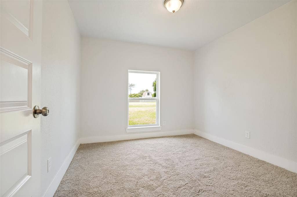 109 Shadow Drive, Red Oak, TX 75154 Bright room featuring neutral-toned carpet, white walls, and a single window offering exterior views