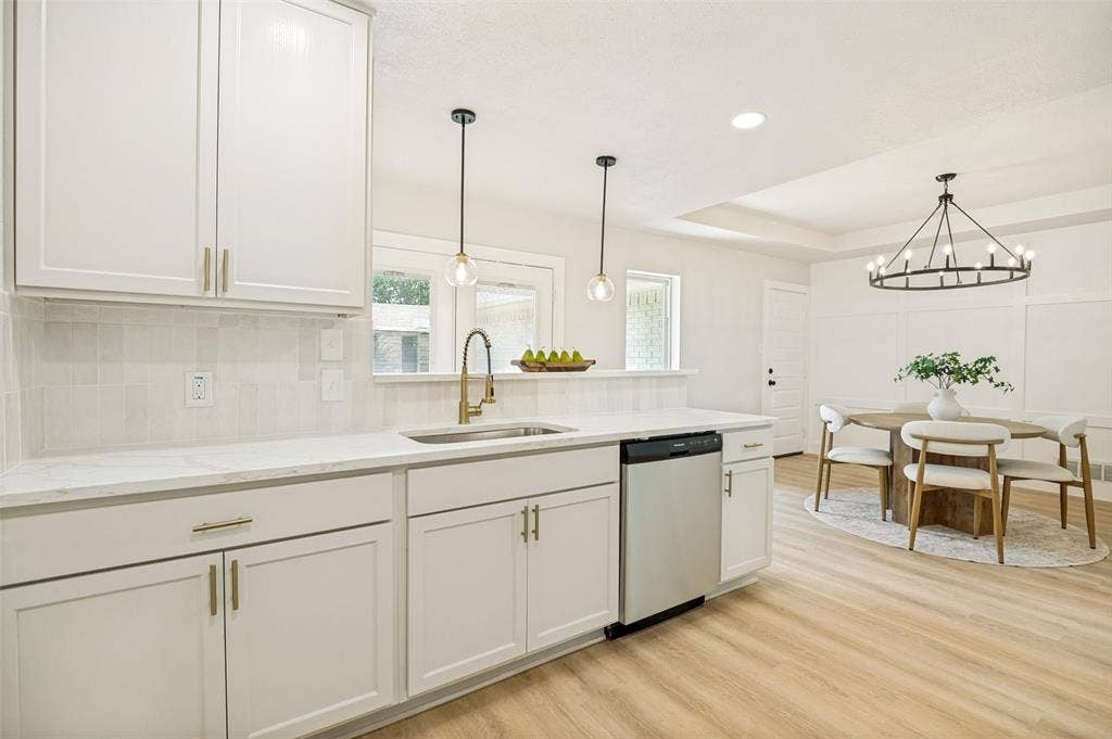 109 Shadow Drive, Red Oak, TX 75154 Contemporary kitchen featuring white cabinetry, light-toned countertops, and a full-height tile backsplash
