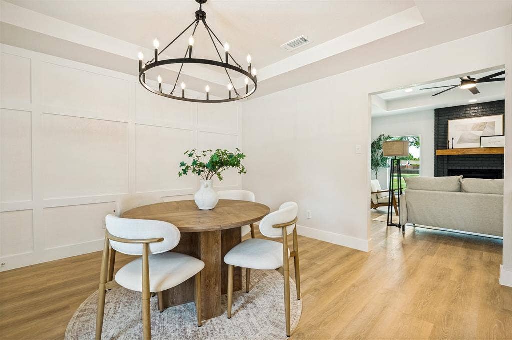 109 Shadow Drive, Red Oak, TX 75154 Dining area featuring board and batten accent wall, wood-finish flooring, and a contemporary chandelier