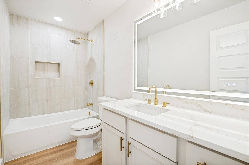 109 Shadow Drive, Red Oak, TX 75154 Contemporary bathroom featuring a white vanity with gold-finish hardware, a rectangular undermount sink, and a stone-finish countertop