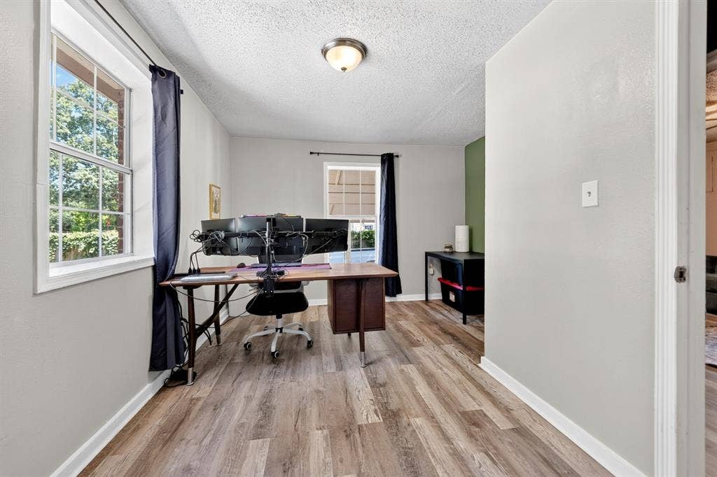 810 Edna Street, Athens, TX 75751 Room with wood-finish flooring, light grey walls, and a multi-pane window