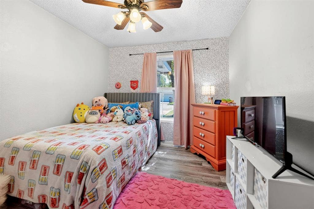 810 Edna Street, Athens, TX 75751 Room featuring wood-finish flooring, a window with natural light, and a ceiling fan with integrated lighting