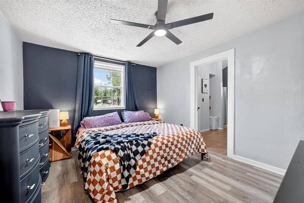 810 Edna Street, Athens, TX 75751 Spacious room featuring wood-finish flooring, a ceiling fan with integrated lighting, and a window with a white frame