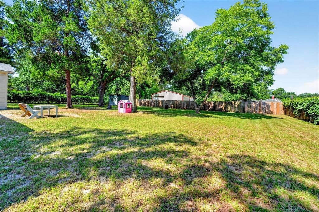 810 Edna Street, Athens, TX 75751 Expansive rear yard featuring mature trees, a privacy fence, and a storage shed