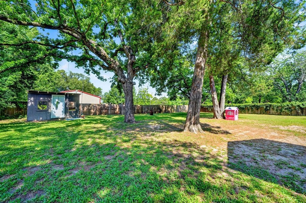 810 Edna Street, Athens, TX 75751 Expansive backyard featuring a large storage shed, mature trees, and a full perimeter fence