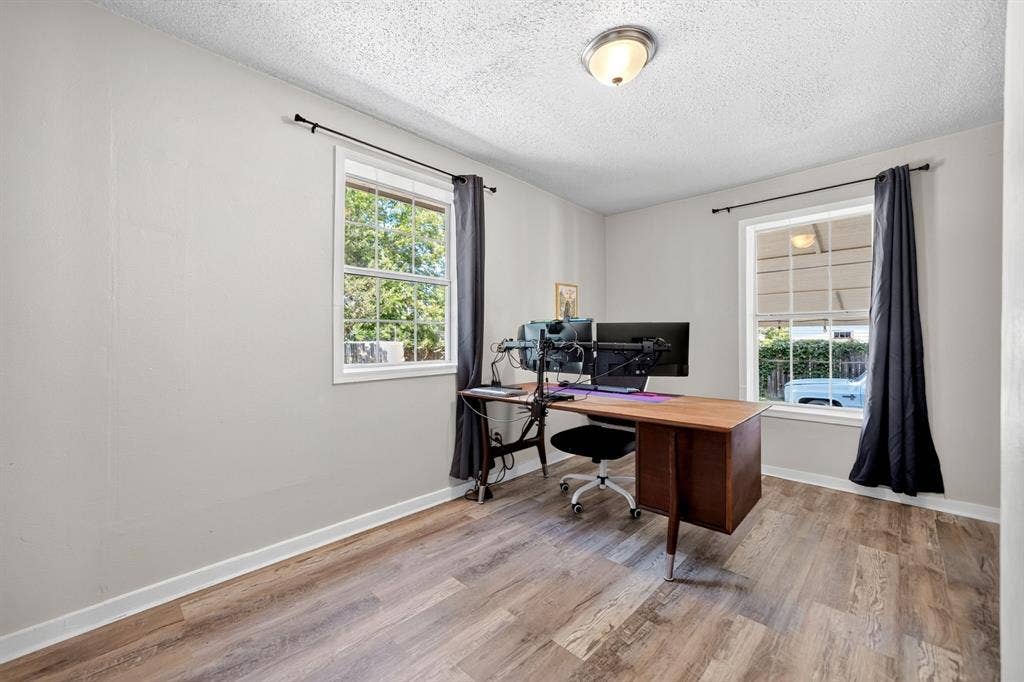810 Edna Street, Athens, TX 75751 Room featuring wood-finish flooring, two windows with white trim, and light gray painted walls