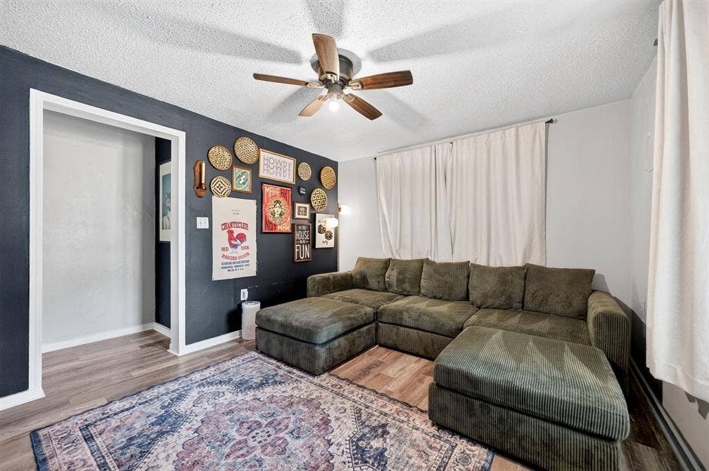 810 Edna Street, Athens, TX 75751 Living area featuring wood-finish flooring, a ceiling fan with integrated lighting, and a doorway with white trim