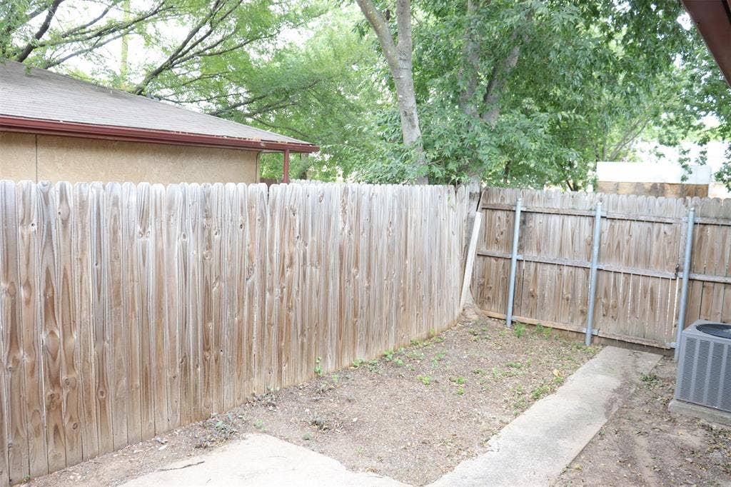 10020 Redondo Drive, Dallas, TX 75218 Private outdoor space featuring a wood fence, concrete patio, and mature trees