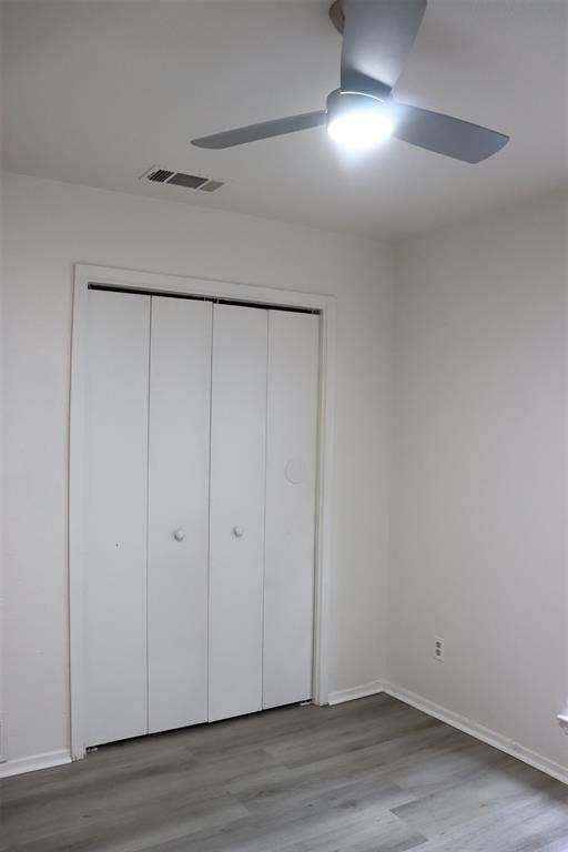 10020 Redondo Drive, Dallas, TX 75218 Room featuring wood-finish flooring, white walls, and a modern ceiling fan with integrated lighting