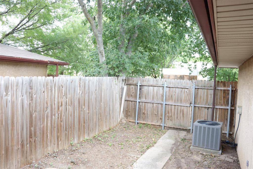 10020 Redondo Drive, Dallas, TX 75218 Private outdoor space featuring a wood picket fence, concrete pathway, and covered patio area