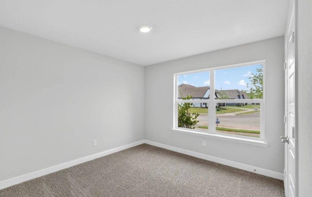 300 Libby Lane, Mansfield, TX 76063 Bright interior space featuring light gray walls, plush gray carpeting, a large window with white trim, and a recessed ceiling light