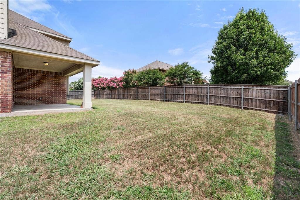 Expansive backyard featuring a covered patio