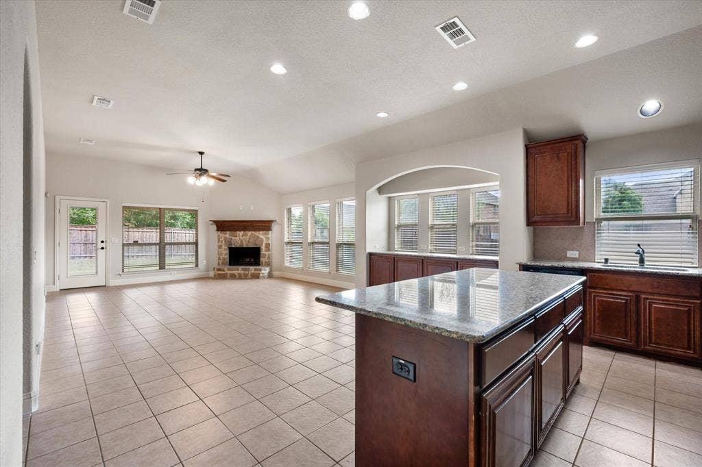 Open-concept living area with a fireplace & recessed lighting