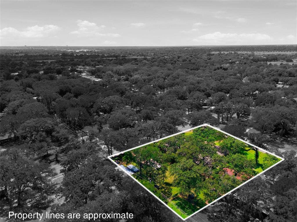 Aerial perspective showcasing a property outlined in white, surrounded by an extensive tree canopy
