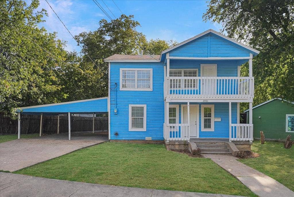 Two-story exterior with a covered balcony, front porch, and an attached carport