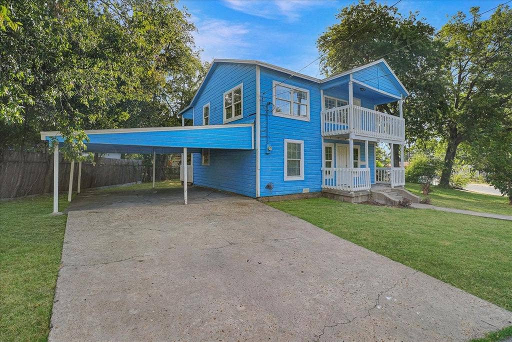Blue exterior with white trim, featuring a two-story covered balcony with white railings
