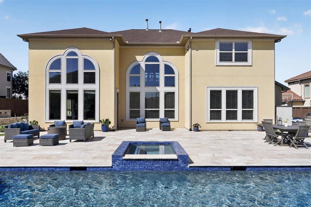 12226 Lazio Lane, Frisco, TX 75035 Expansive exterior patio featuring a built-in spa, a swimming pool with blue tile accents, and a light-colored paver surface