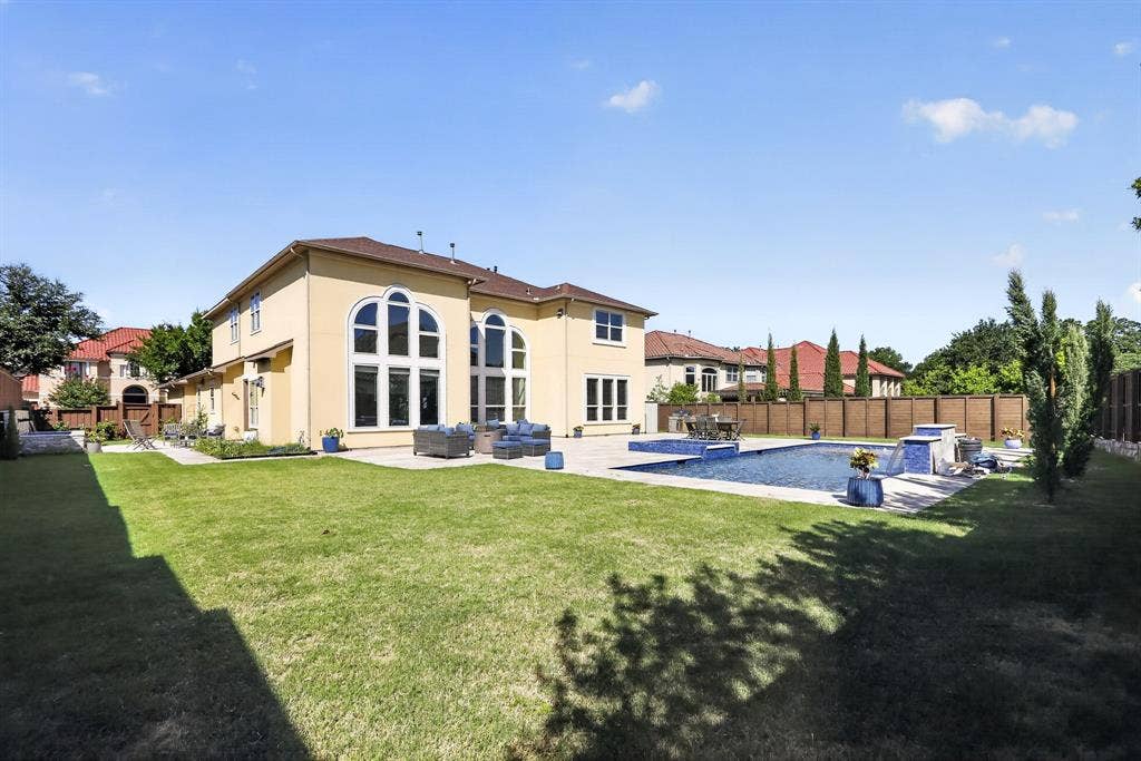 12226 Lazio Lane, Frisco, TX 75035 Expansive backyard featuring a rectangular swimming pool with integrated spa and waterfall features