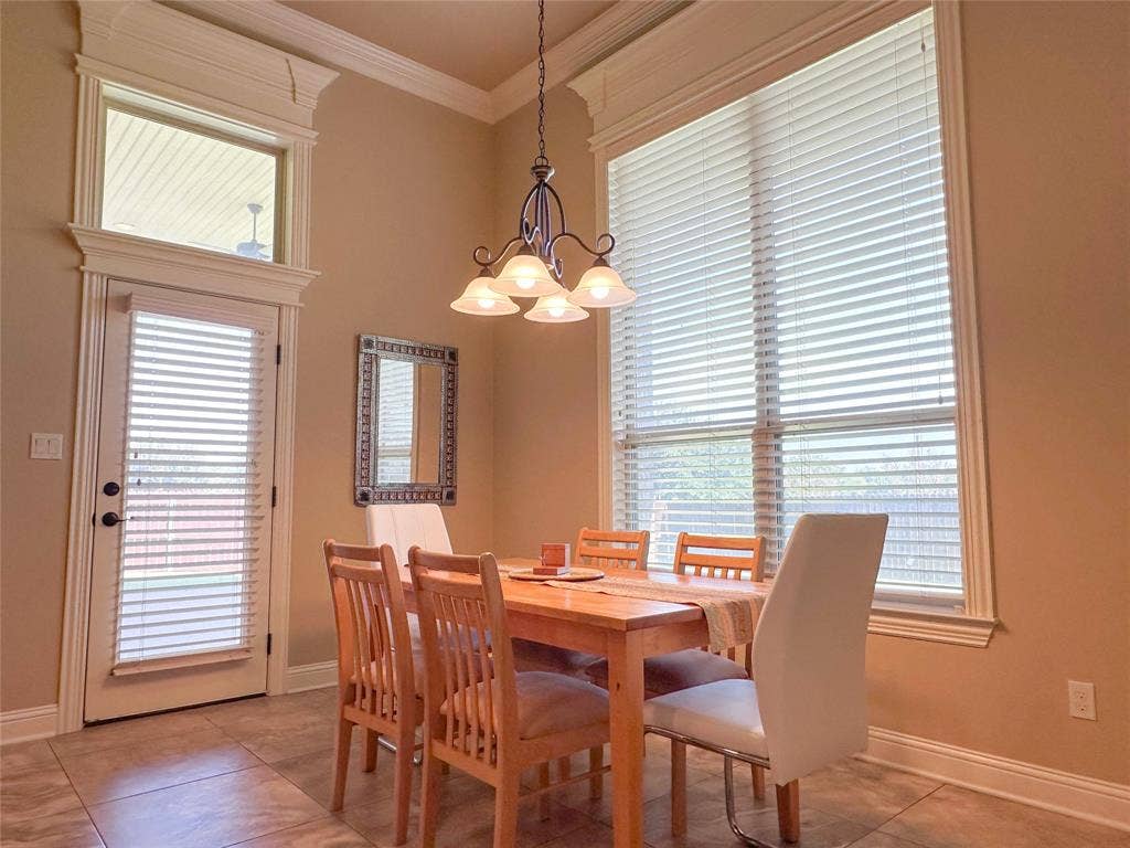 1100 Wessex Drive, Woodway, TX 76712 Dining area featuring a high ceiling, crown molding, and tiled flooring