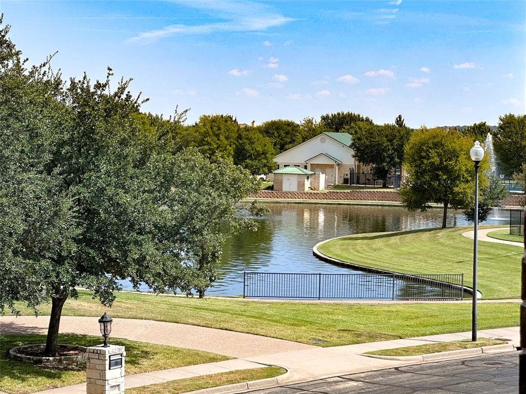 1100 Wessex Drive, Woodway, TX 76712 Waterfront property featuring a curved shoreline, manicured green space, and mature trees