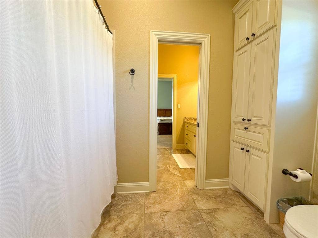 1100 Wessex Drive, Woodway, TX 76712 Bathroom with tile flooring, white shower curtain, and built-in white cabinetry