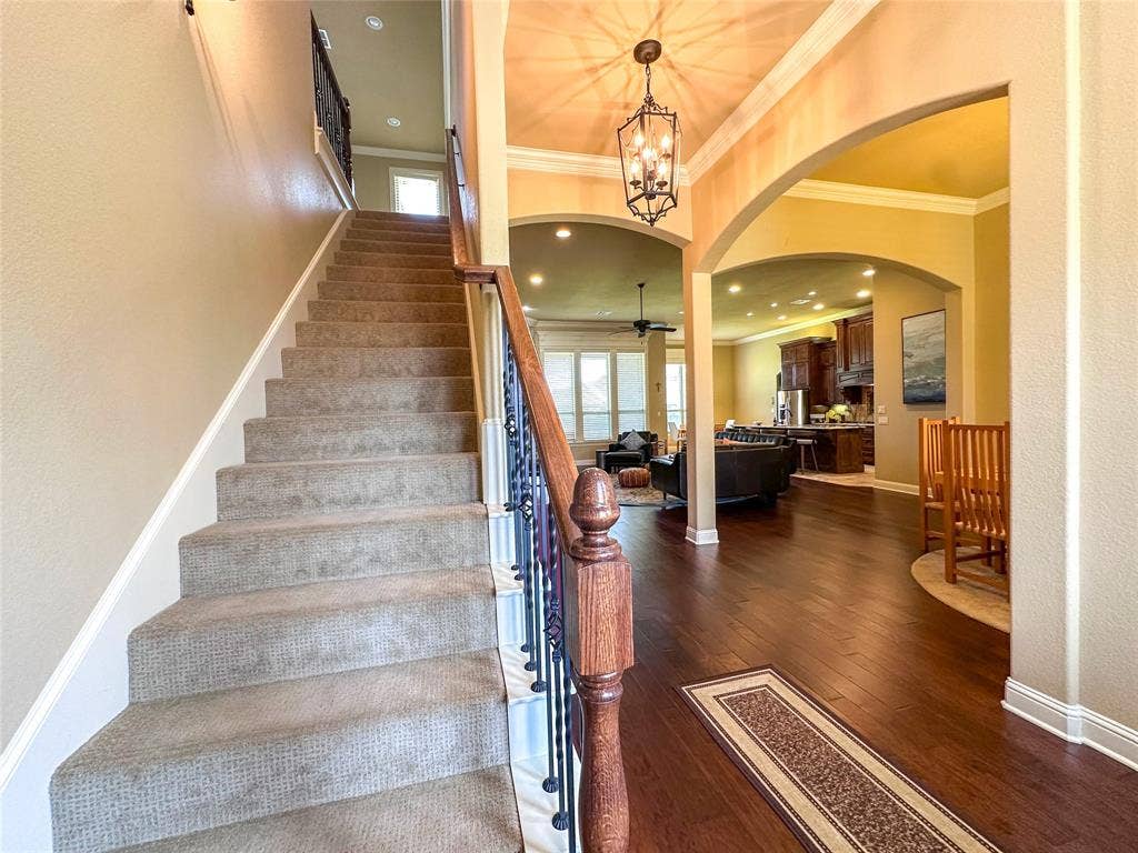 1100 Wessex Drive, Woodway, TX 76712 Grand entryway featuring a carpeted staircase with wrought iron balusters and a wood handrail