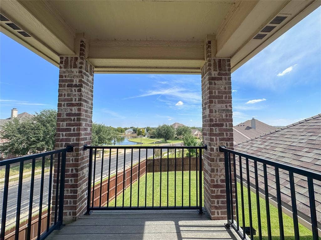 1100 Wessex Drive, Woodway, TX 76712 Second-story balcony featuring brick columns, black metal railing, and composite decking