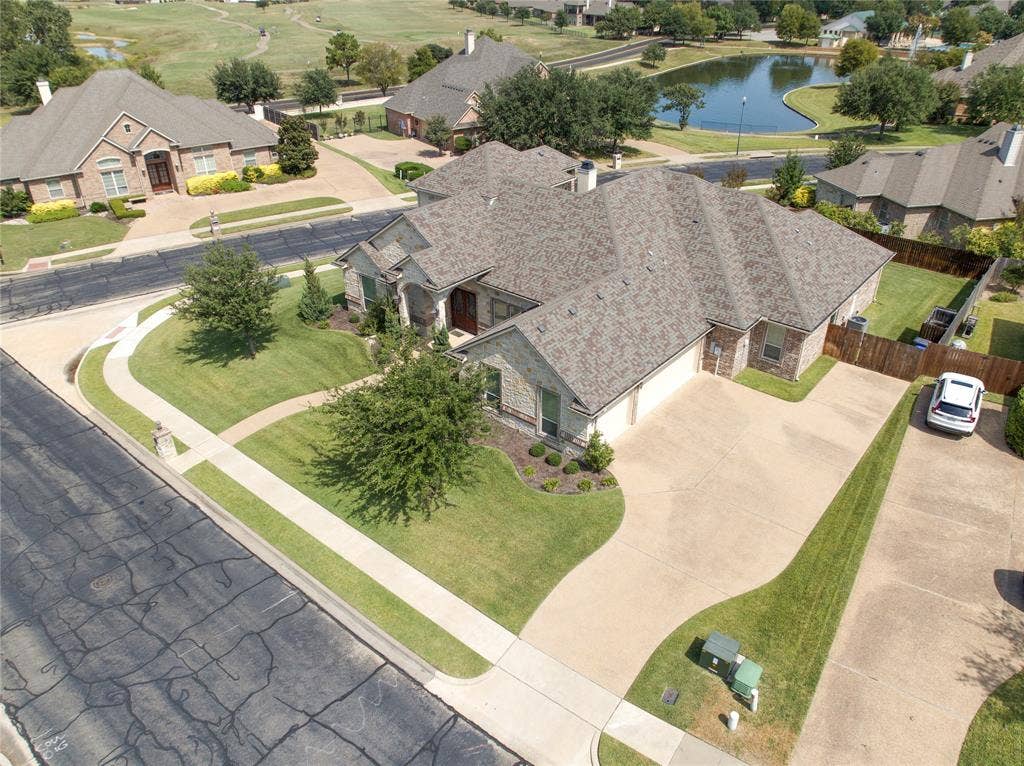 1100 Wessex Drive, Woodway, TX 76712 Expansive residential property featuring a stone and brick exterior with a multi-gabled roofline