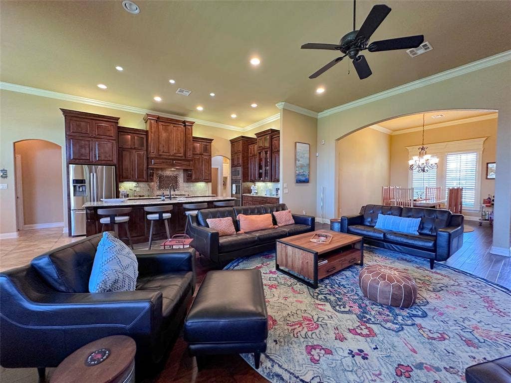 1100 Wessex Drive, Woodway, TX 76712 Open-concept living area featuring wood-finish flooring, a ceiling fan, recessed lighting, and crown molding