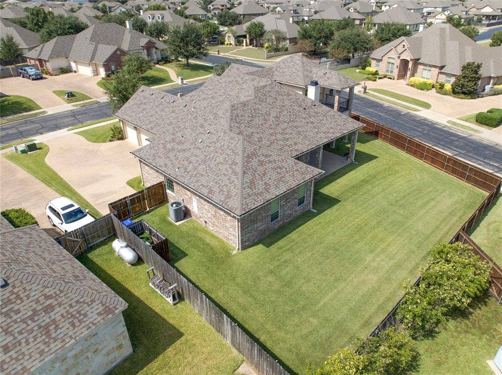 1100 Wessex Drive, Woodway, TX 76712 Expansive backyard featuring a manicured lawn, full perimeter privacy fencing, and a covered patio area