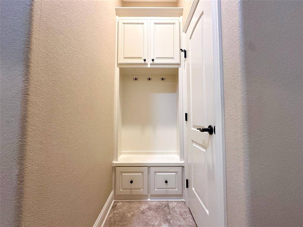 1100 Wessex Drive, Woodway, TX 76712 Built-in mudroom station featuring upper cabinetry, storage bench, three coat hooks, and two lower drawers