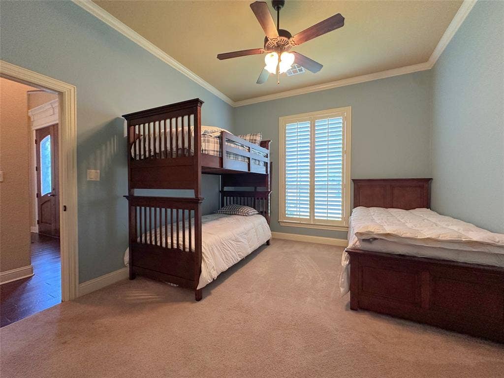 1100 Wessex Drive, Woodway, TX 76712 Bedroom featuring light blue walls, a ceiling fan with light fixture, and crown molding