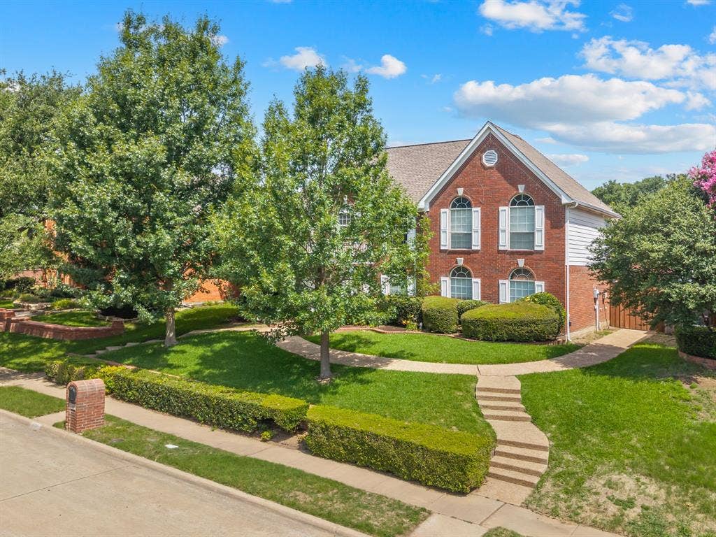 669 Water Oak Drive, Plano, TX 75025 Brick-clad exterior featuring white siding and a gabled roofline