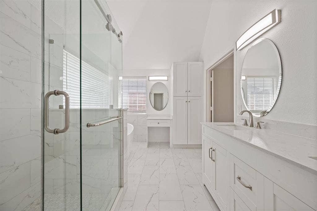 669 Water Oak Drive, Plano, TX 75025 Spacious bathroom featuring a glass-enclosed shower, dual vanity with undermount sinks and brushed nickel fixtures, white cabinetry, and large format tile flooring